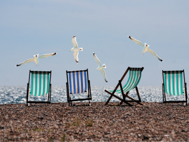 Solstole på en strand der symboliserer ferie